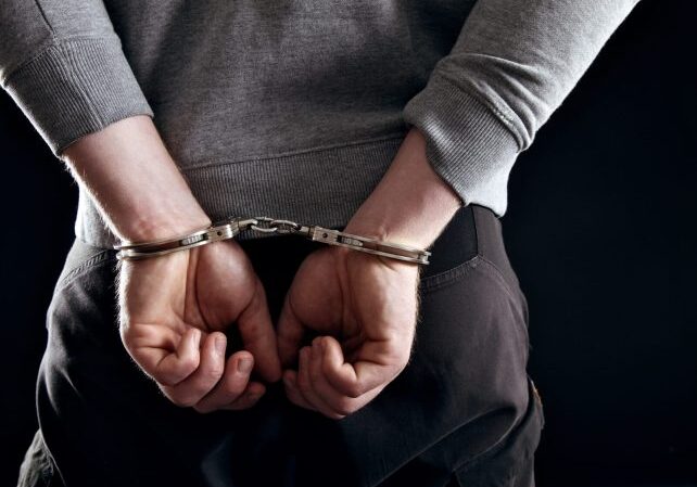 outlaws-hands-locked-in-handcuffs-isolated-on-black_B6bTGkIEtl